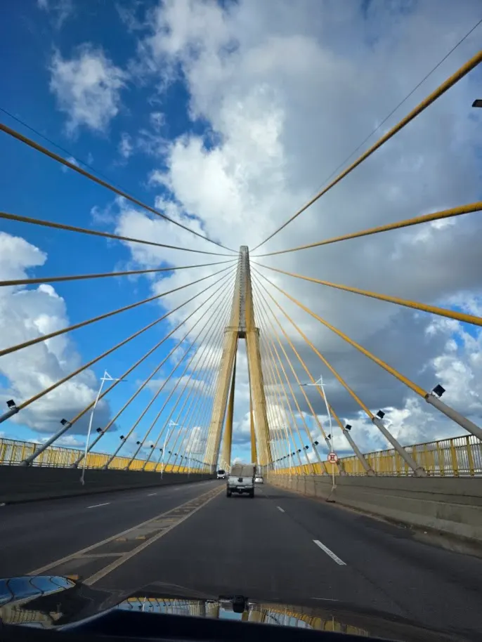 Crossing the bridge over the Rio Negro, the cables fanning out against the Manaus sky