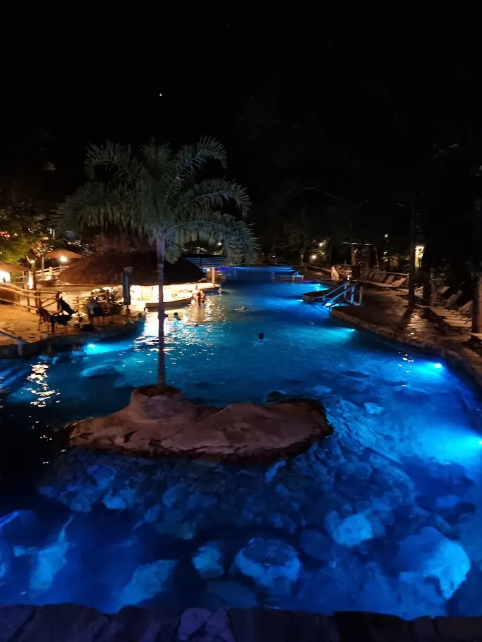 Hot spring pools lit blue at night in Rio Quente
