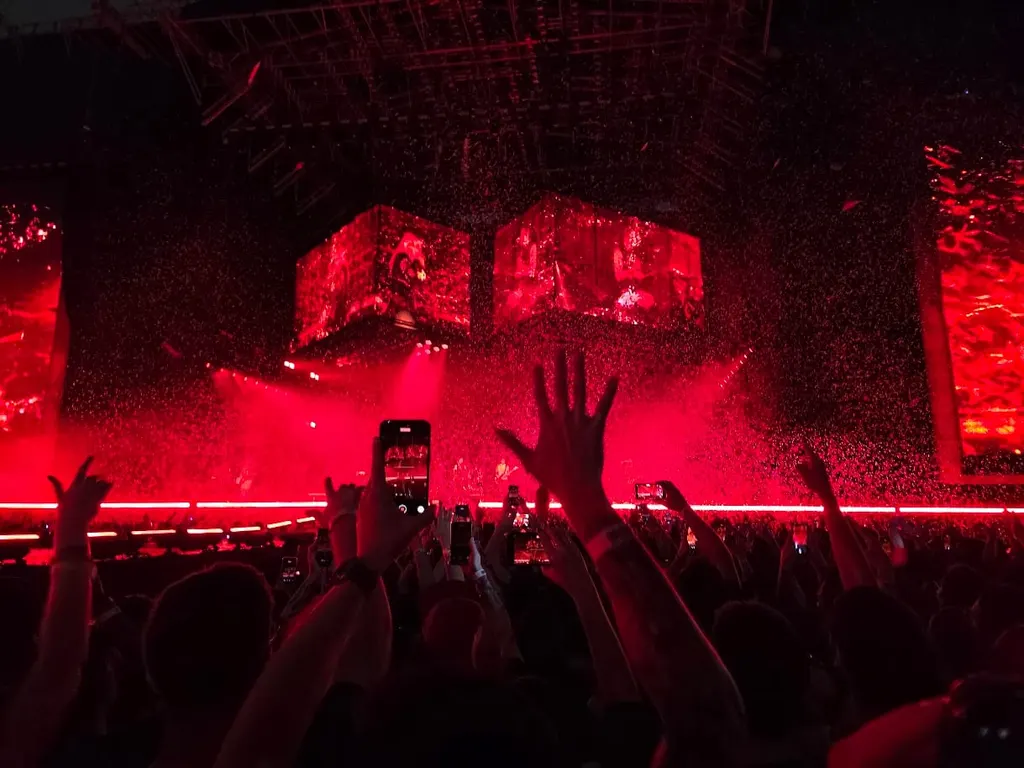 Concert crowd under red confetti at a Linkin Park show