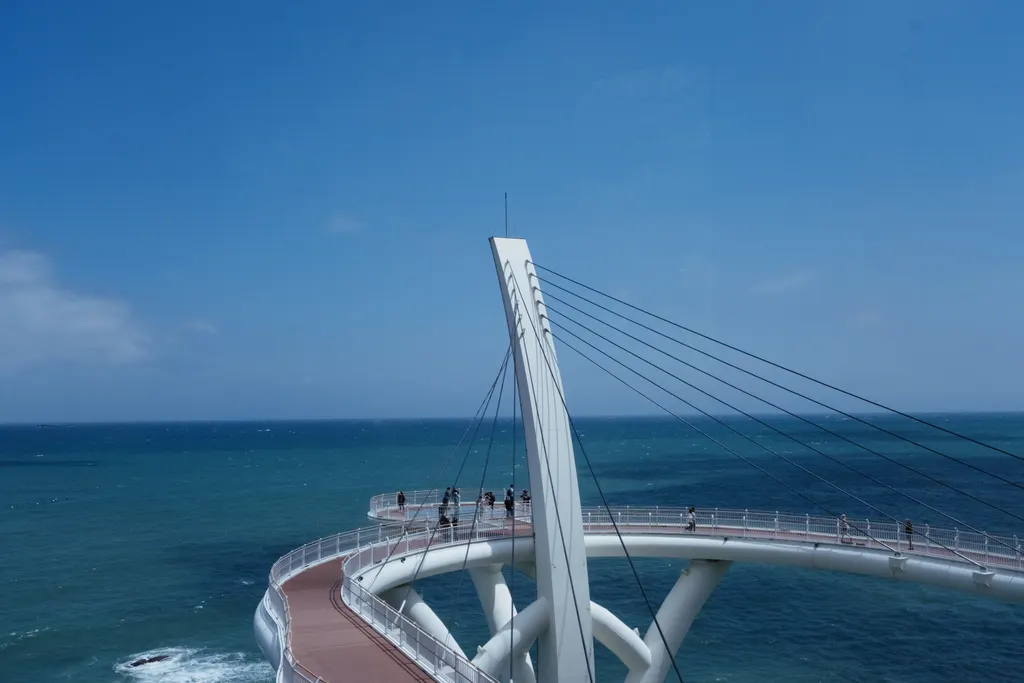 The white cable-stayed skywalk curving out over the sea at Cheongsapo